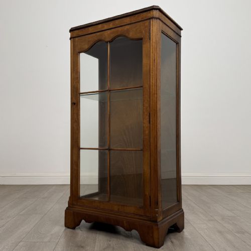 fig 2. A standing burr walnut display cabinet with a single six-pane glass door and a bracket foot base.