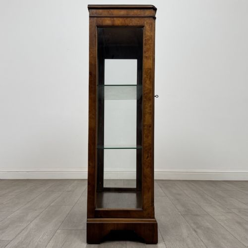 fig 7. A standing burr walnut display cabinet with a single six-pane glass door and a bracket foot base.