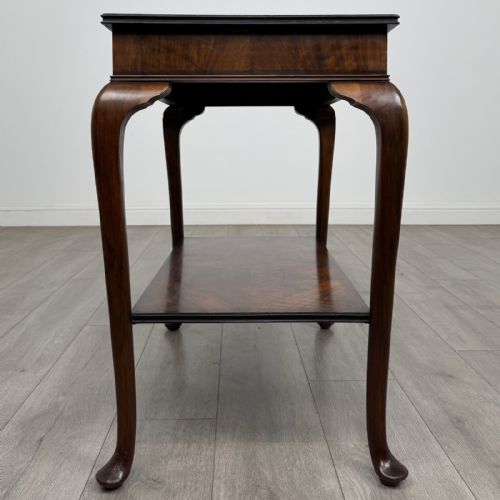 fig 2. An Edwardian burr walnut side table featuring cabriole legs, pad feet, a lower shelf, and a rectangular top with deep apron.