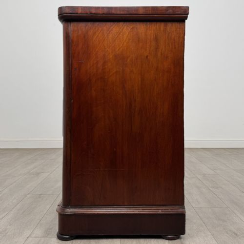 fig 2. An antique Victorian mahogany chest of drawers featuring two short drawers over two long drawers with turned wooden handles and a plinth base.