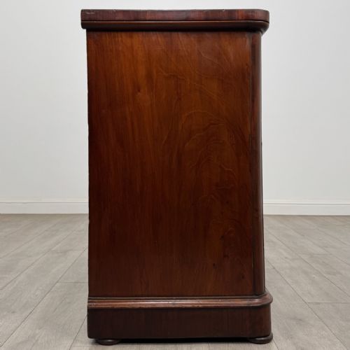 fig 6. An antique Victorian mahogany chest of drawers featuring two short drawers over two long drawers with turned wooden handles and a plinth base.