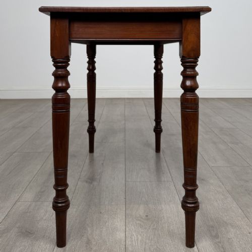 fig 2. An Edwardian walnut side table featuring a rectangular top, plain apron, and four reeded turned legs.