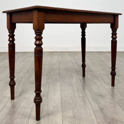 fig 3. An Edwardian walnut side table featuring a rectangular top, plain apron, and four reeded turned legs.