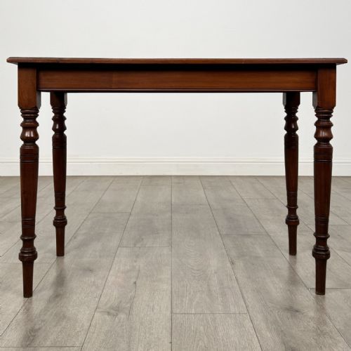 fig 4. An Edwardian walnut side table featuring a rectangular top, plain apron, and four reeded turned legs.