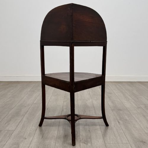 fig 3. A Georgian style mahogany corner washstand with a high curved splashback gallery, central drawer tier with brass rosette handles, and splayed legs joined by a circular lower stretcher.