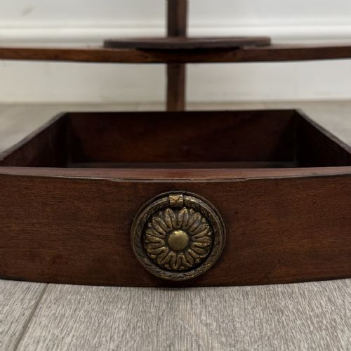 fig 8. A Georgian style mahogany corner washstand with a high curved splashback gallery, central drawer tier with brass rosette handles, and splayed legs joined by a circular lower stretcher.