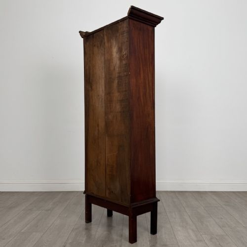 fig 5. A tall, narrow Georgian mahogany display cabinet featuring a single geometric astragal glazed door and internal fabric-lined shelves.