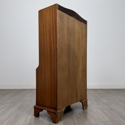 fig 3. A mahogany open bookcase featuring two upper shelves with shaped side galleries above a two-door lower cupboard on bracket feet.