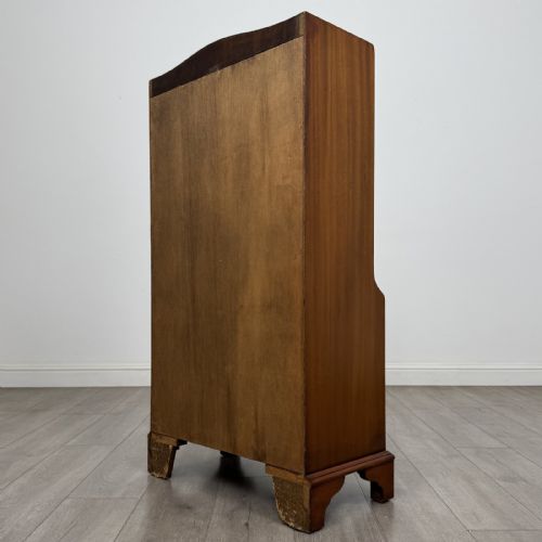 fig 5. A mahogany open bookcase featuring two upper shelves with shaped side galleries above a two-door lower cupboard on bracket feet.