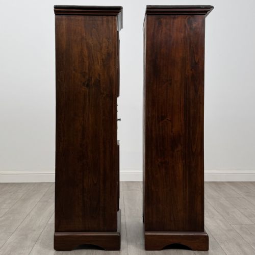 fig 7. A pair of tall dark brown hardwood cupboards featuring a central drawer and panelled doors, with one lower panel decorated with a painted urn motif.