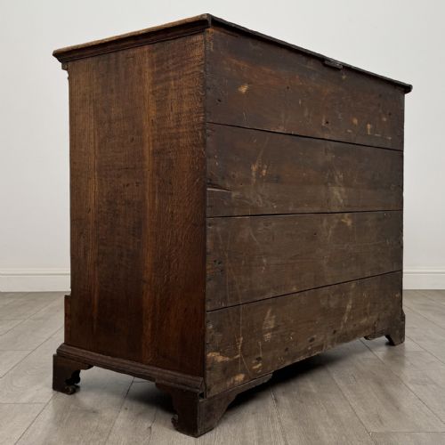 fig 3. An eighteenth-century Georgian oak chest of drawers featuring two short drawers over three long drawers with brass swan-neck handles and bracket feet.