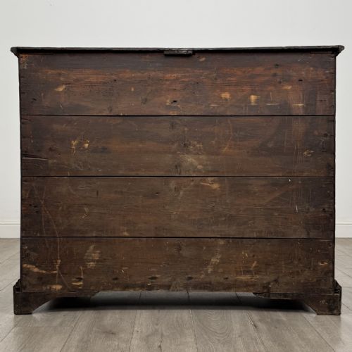 fig 4. An eighteenth-century Georgian oak chest of drawers featuring two short drawers over three long drawers with brass swan-neck handles and bracket feet.