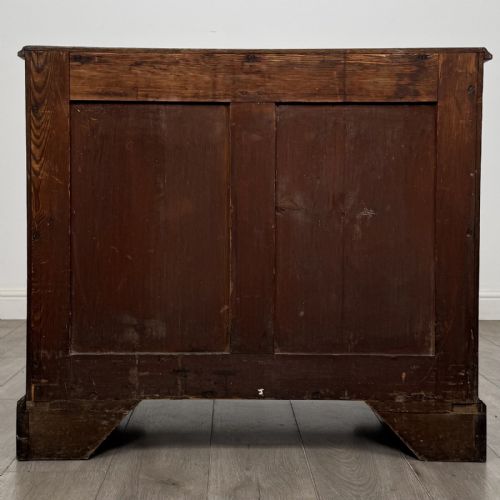 fig 4. An 18th-century dark mahogany low cupboard featuring twin panelled doors with brass keyhole escutcheons resting on bracket feet.