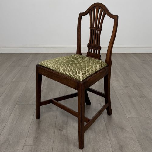 fig 1. A set of four 18th-century Georgian mahogany dining chairs featuring carved pierced back splats and green patterned upholstered seats.