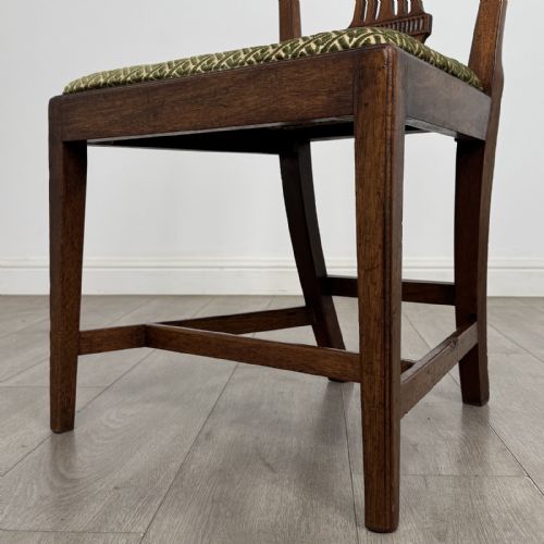 fig 4. A set of four 18th-century Georgian mahogany dining chairs featuring carved pierced back splats and green patterned upholstered seats.