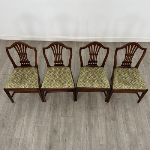 fig 6. A set of four 18th-century Georgian mahogany dining chairs featuring carved pierced back splats and green patterned upholstered seats.
