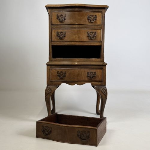 fig 8. A tall mahogany chest of drawers featuring four stacked drawers with brass handles, resting on carved cabriole legs with pad feet.