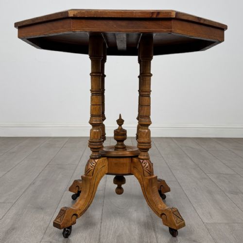 fig 2. A Victorian octagonal walnut side table featuring turned support columns, a central finial, and carved splayed legs with castors.