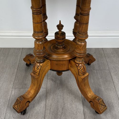 fig 5. A Victorian octagonal walnut side table featuring turned support columns, a central finial, and carved splayed legs with castors.