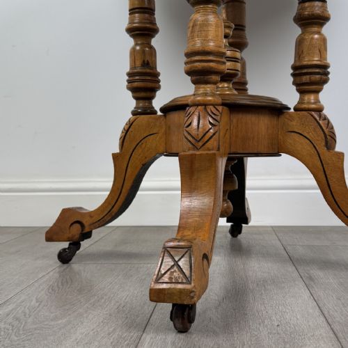 fig 6. A Victorian octagonal walnut side table featuring turned support columns, a central finial, and carved splayed legs with castors.
