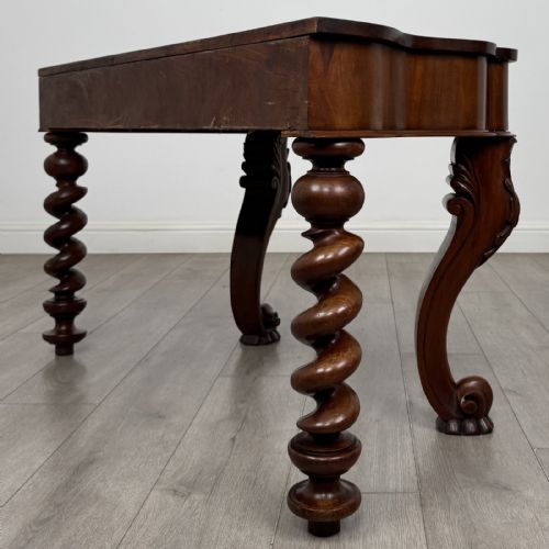 fig 5. A Victorian mahogany console table with carved cabriole front legs, spiral rear legs, and a single drawer with round wooden handles.