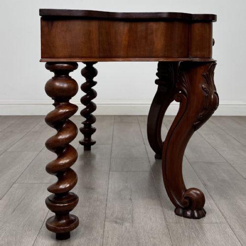 fig 6. A Victorian mahogany console table with carved cabriole front legs, spiral rear legs, and a single drawer with round wooden handles.