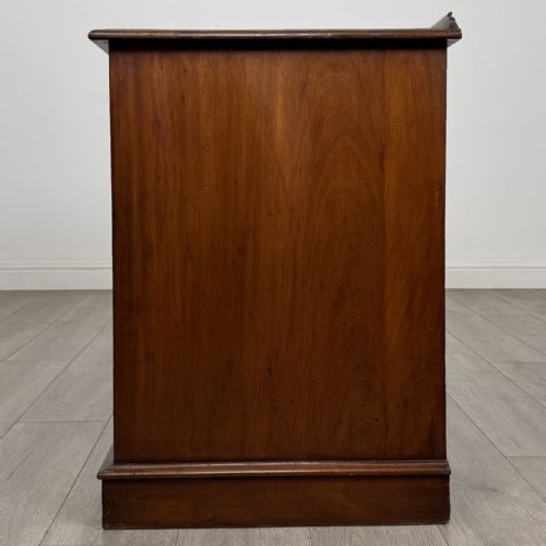 fig 2. A Victorian mahogany pedestal desk featuring nine drawers fitted with brass swan neck handles and a central kneehole, supported on plinth bases.