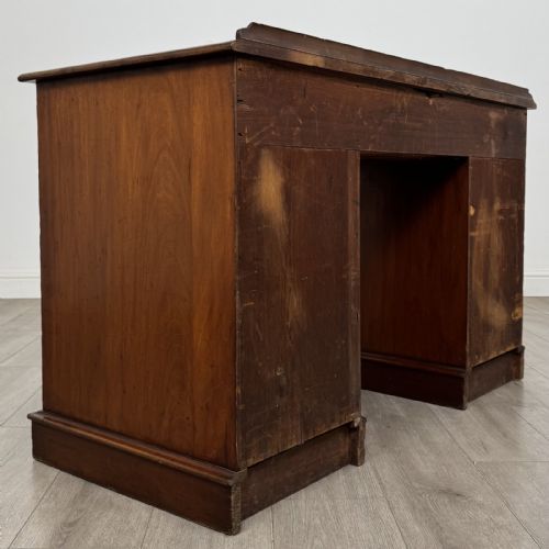 fig 3. A Victorian mahogany pedestal desk featuring nine drawers fitted with brass swan neck handles and a central kneehole, supported on plinth bases.