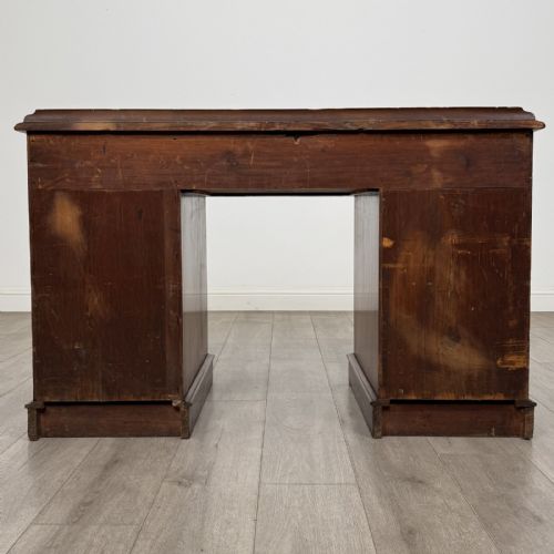 fig 4. A Victorian mahogany pedestal desk featuring nine drawers fitted with brass swan neck handles and a central kneehole, supported on plinth bases.