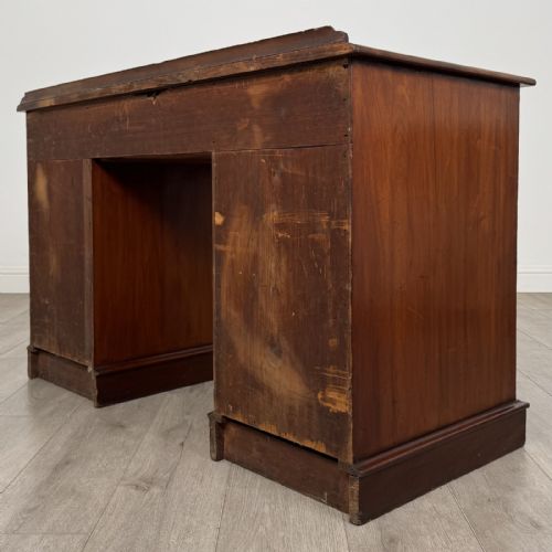 fig 5. A Victorian mahogany pedestal desk featuring nine drawers fitted with brass swan neck handles and a central kneehole, supported on plinth bases.
