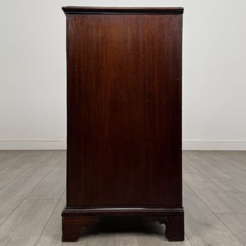 fig 2. An eighteenth-century Georgian mahogany chest of drawers featuring two short over three long graduated drawers with brass swan-neck handles and bracket feet.