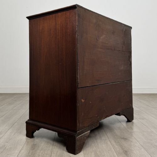 fig 3. An eighteenth-century Georgian mahogany chest of drawers featuring two short over three long graduated drawers with brass swan-neck handles and bracket feet.