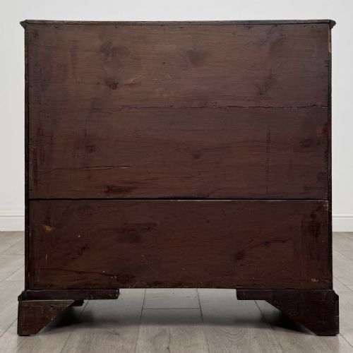 fig 4. An eighteenth-century Georgian mahogany chest of drawers featuring two short over three long graduated drawers with brass swan-neck handles and bracket feet.