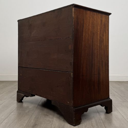 fig 5. An eighteenth-century Georgian mahogany chest of drawers featuring two short over three long graduated drawers with brass swan-neck handles and bracket feet.