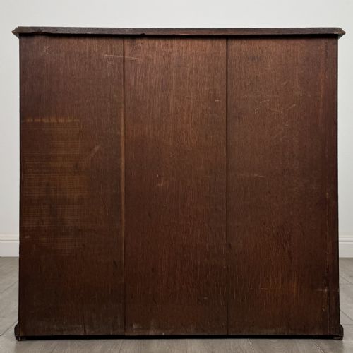 fig 4. A low Edwardian solid oak open bookcase featuring three wide shelves and a dark polished finish.
