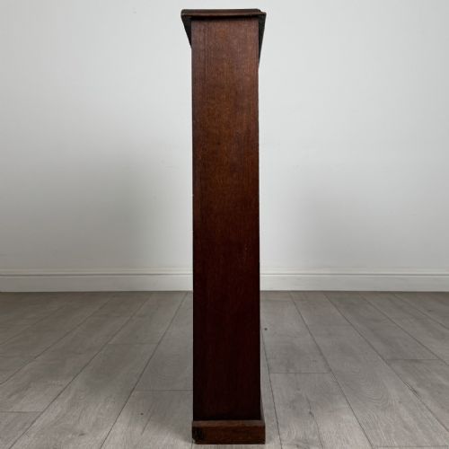 fig 6. A low Edwardian solid oak open bookcase featuring three wide shelves and a dark polished finish.