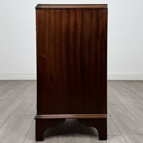 fig 2. A Georgian style mahogany serpentine chest featuring four graduated drawers with brass drop handles and bracket feet.