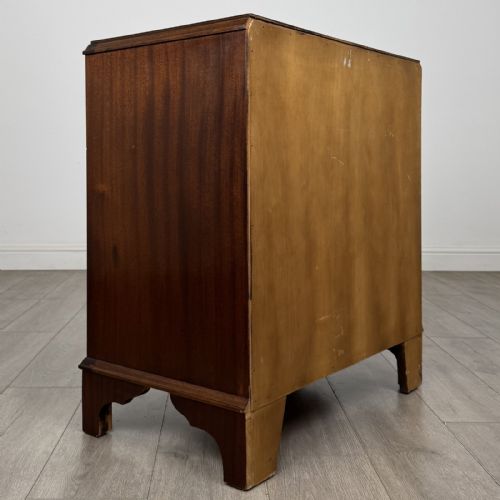 fig 3. A Georgian style mahogany serpentine chest featuring four graduated drawers with brass drop handles and bracket feet.