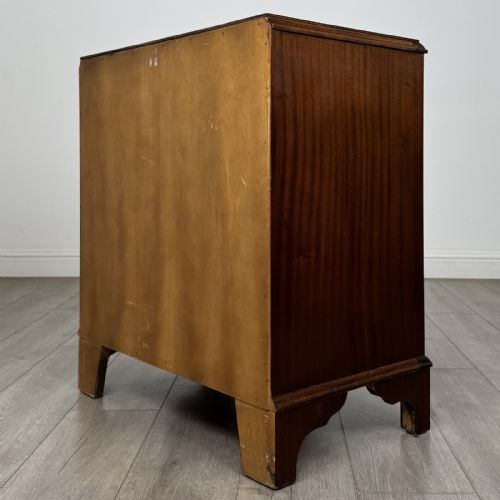 fig 5. A Georgian style mahogany serpentine chest featuring four graduated drawers with brass drop handles and bracket feet.