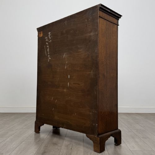 fig 6. A dark oak Georgian style display cabinet featuring twin glazed doors with rectangular timber mullions and bracket feet.