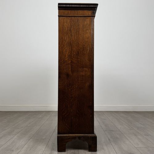 fig 7. A dark oak Georgian style display cabinet featuring twin glazed doors with rectangular timber mullions and bracket feet.