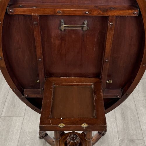 fig 4. A Victorian burr walnut tilt-top loo table featuring an oval top supported by four turned columns and carved quadform legs with scroll feet.