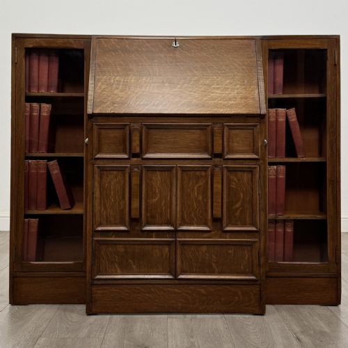 fig 1. An Art Deco oak side-by-side bureau bookcase with a central slant-front desk above panelled cupboards, flanked by two glazed display cabinets.