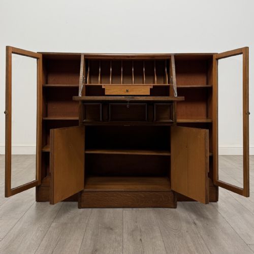 fig 2. An Art Deco oak side-by-side bureau bookcase with a central slant-front desk above panelled cupboards, flanked by two glazed display cabinets.