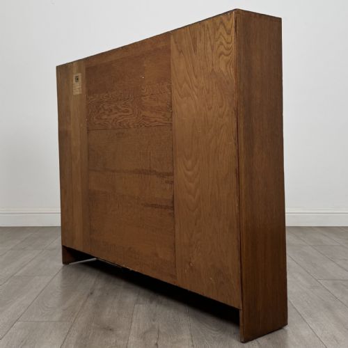 fig 7. An Art Deco oak side-by-side bureau bookcase with a central slant-front desk above panelled cupboards, flanked by two glazed display cabinets.