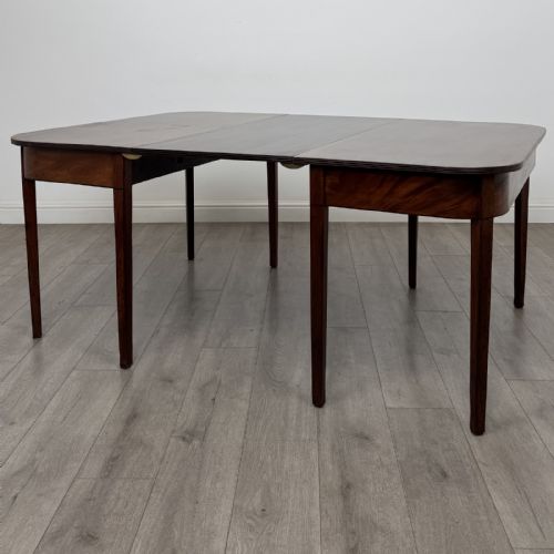 fig 1. An antique Georgian dark mahogany extending dining table featuring rounded D-end corners, a removable leaf, and square tapered legs.