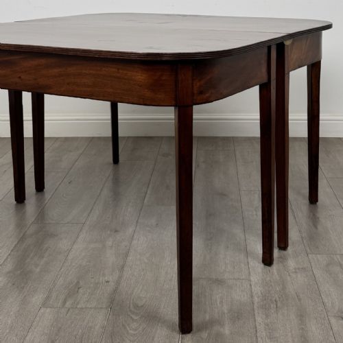 fig 3. An antique Georgian dark mahogany extending dining table featuring rounded D-end corners, a removable leaf, and square tapered legs.