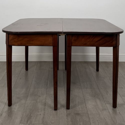 fig 4. An antique Georgian dark mahogany extending dining table featuring rounded D-end corners, a removable leaf, and square tapered legs.