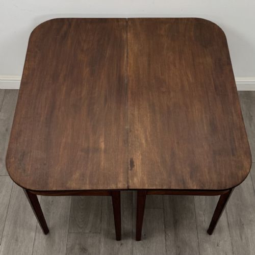 fig 5. An antique Georgian dark mahogany extending dining table featuring rounded D-end corners, a removable leaf, and square tapered legs.