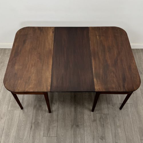 fig 6. An antique Georgian dark mahogany extending dining table featuring rounded D-end corners, a removable leaf, and square tapered legs.